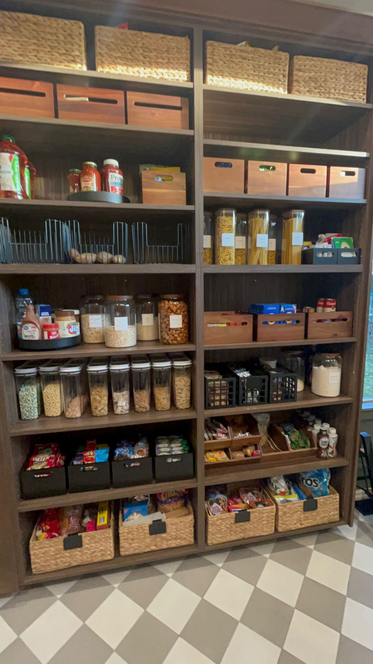 Beautifully organized pantry with labeled jars and woven baskets