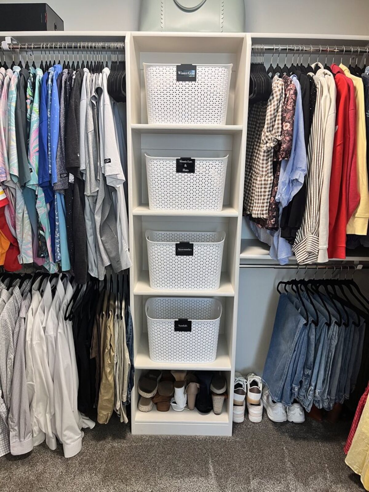 Organized closet with white bins and hanging clothes